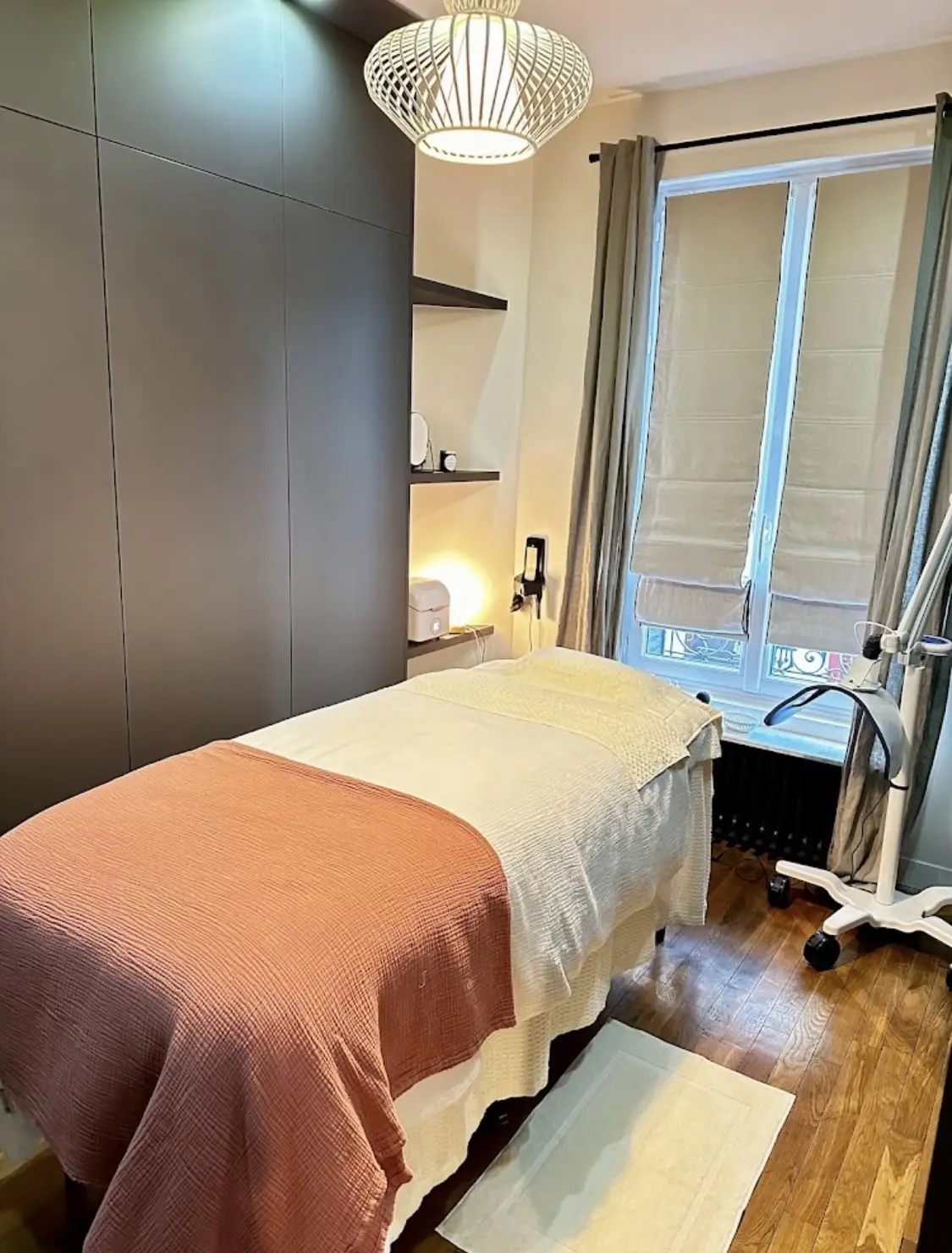 Cabine de soin Pimp My Derm : table de massage, plaid terracotta, lumière douce et parquet