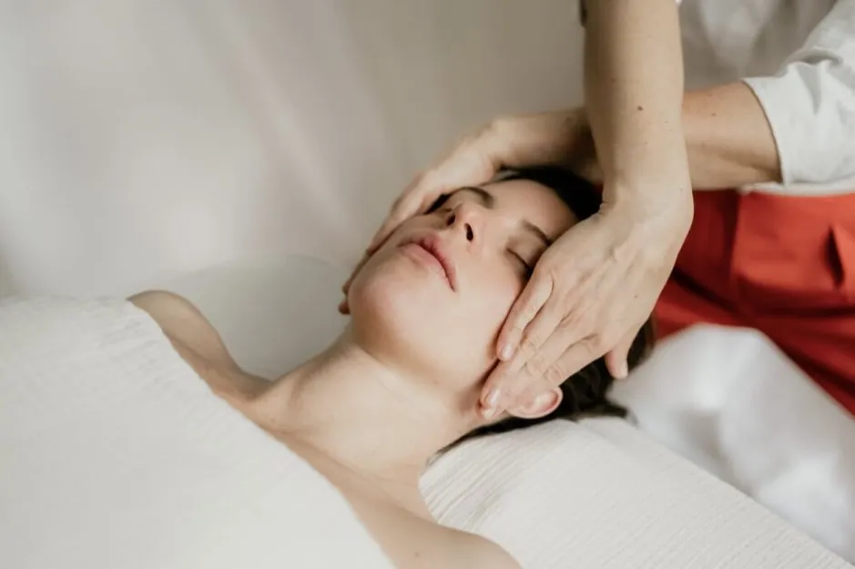 Virginie Tran pratiquant un massage facial des tempes sur une cliente détendue